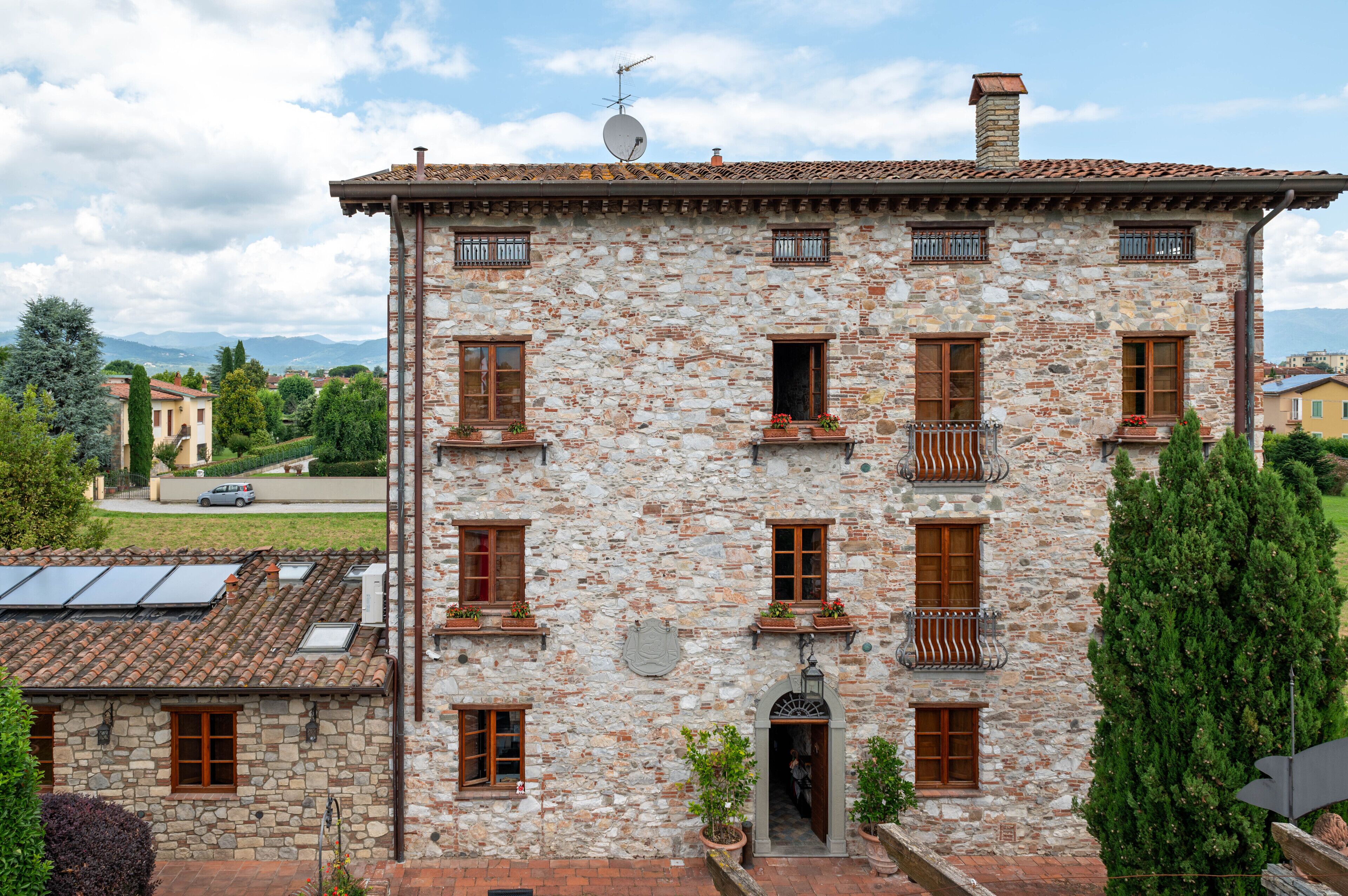 Un edificio in pietra con diverse finestre e un balcone.