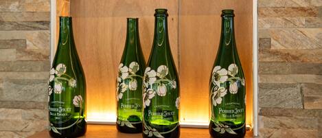 Quattro bottiglie di champagne Perrier Jouët Belle Époque in un espositore di legno.
