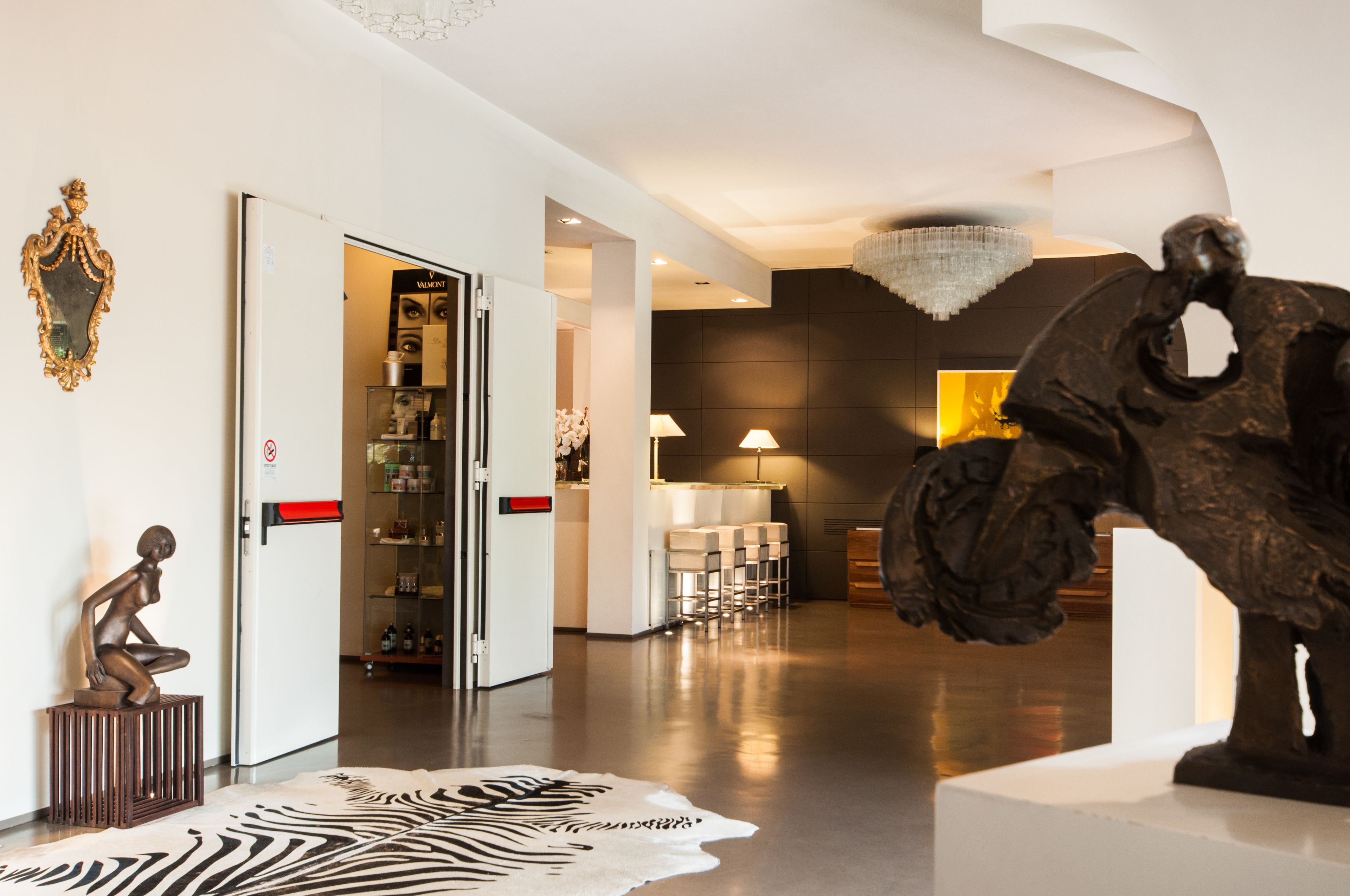 A modern interior with a zebra-patterned rug, a sculpture, and a bar area with seating.