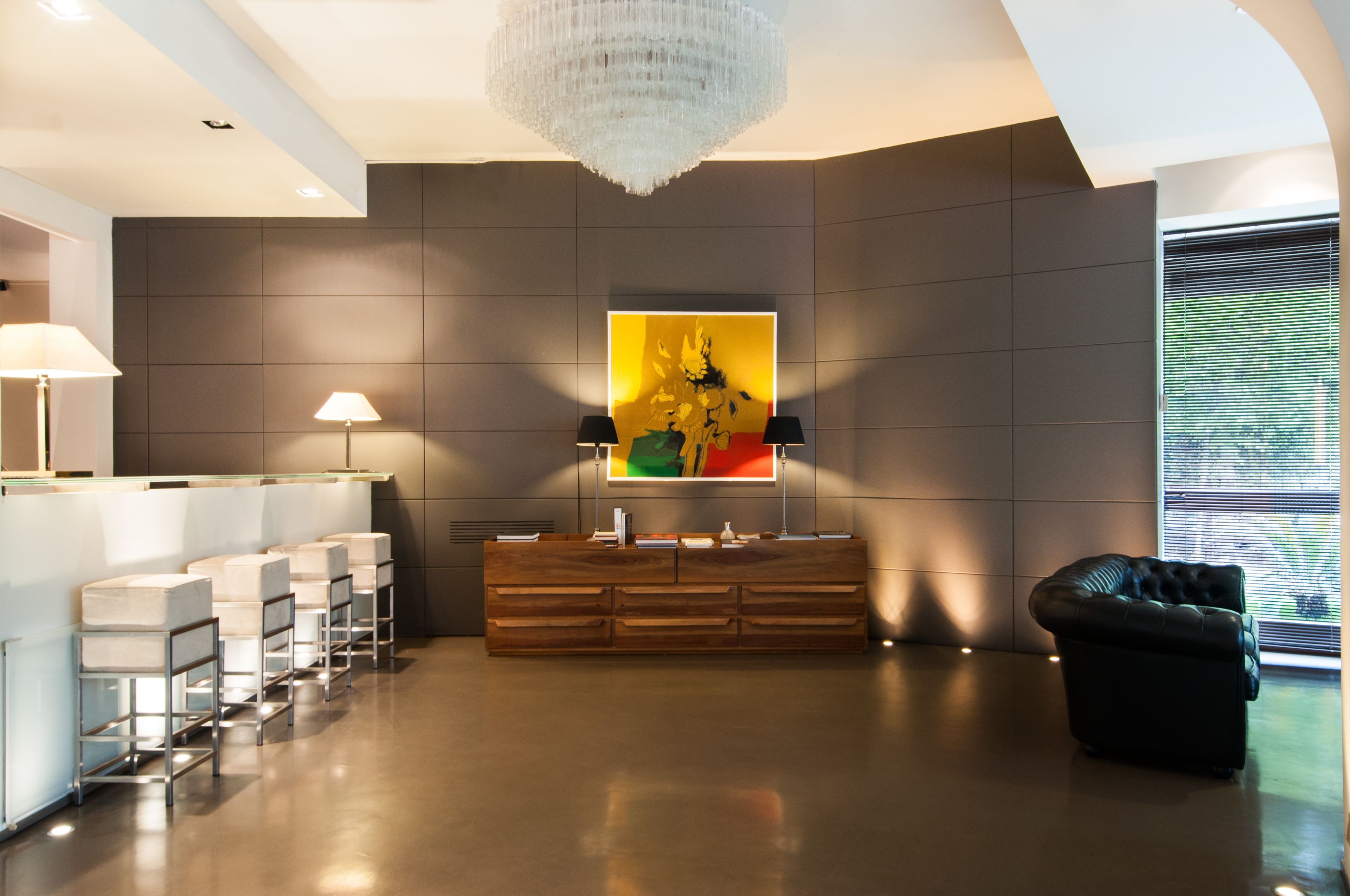 A modern lobby with a reception desk, seating area, and a large painting on the wall.