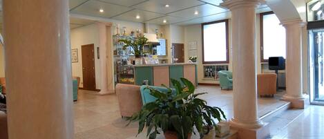 A spacious lobby with a reception desk, seating area, and a bar.