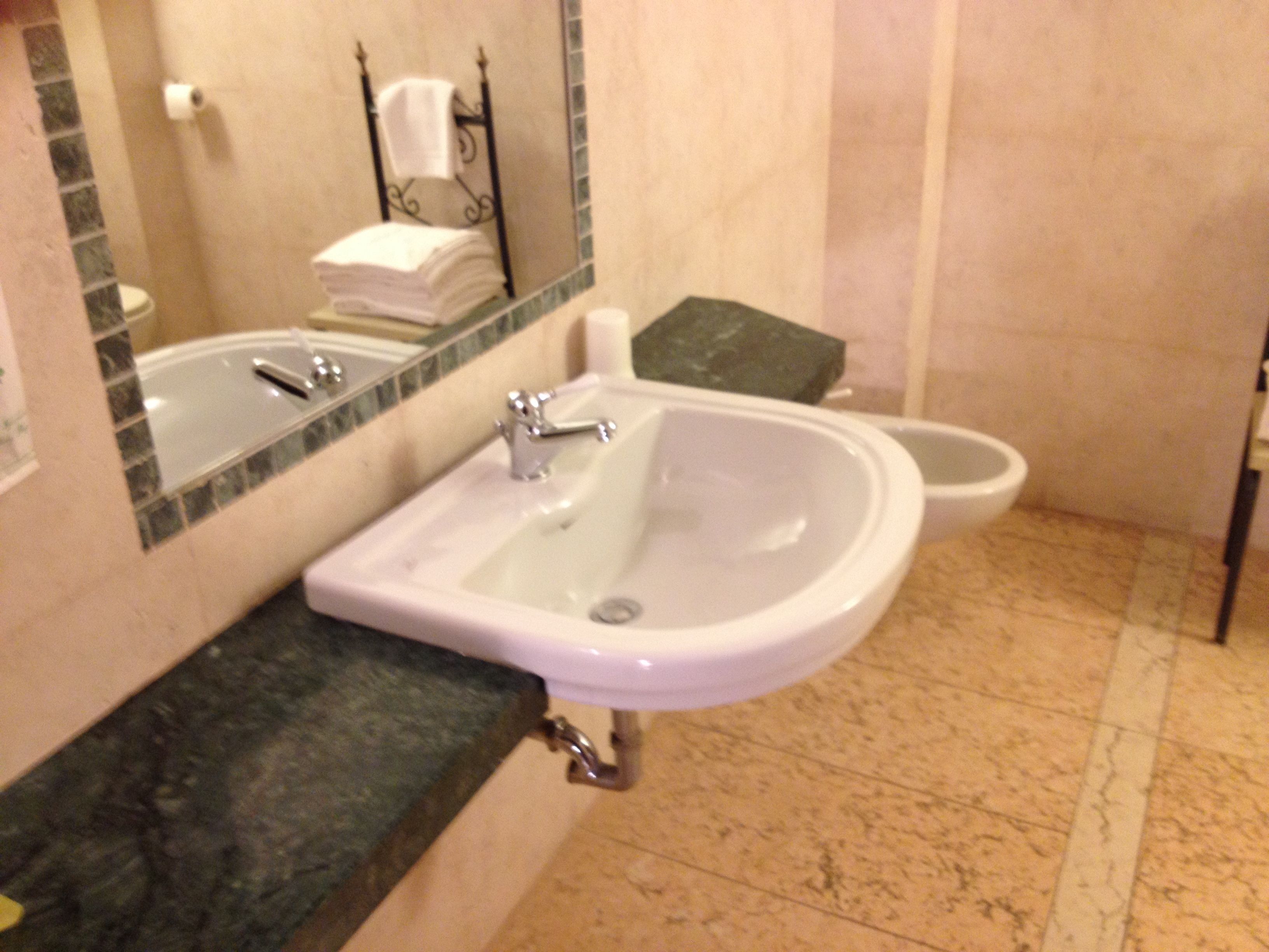 Un baño con lavamanos, espejo y retrete.