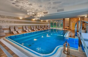 Una piscina techada, una piscina al aire libre, sombrillas
