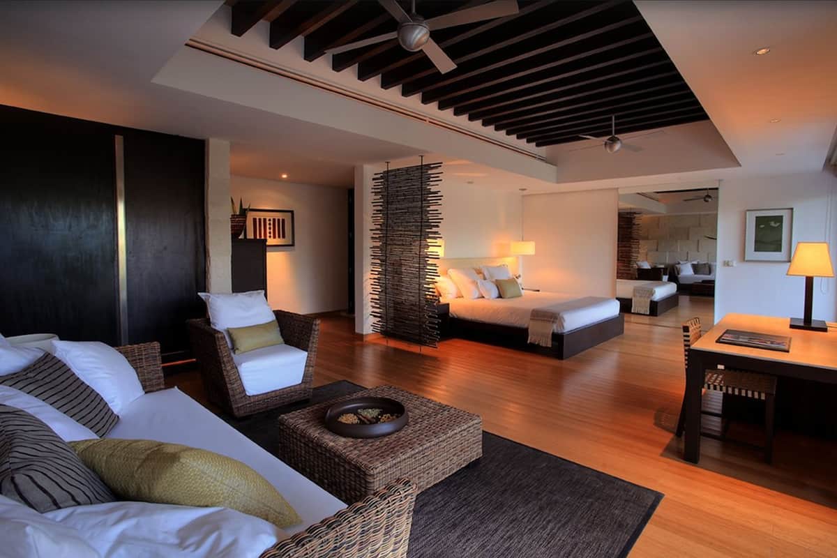 Une chambre d’hôtel moderne dotée d’un grand lit, d’un canapé, d’un coin repas et d’un espace de vie séparé.