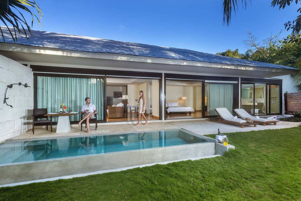 Une maison moderne dotée d’une piscine, d’un coin repas et d’une chambre avec une grande fenêtre.