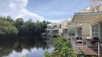Un hotel moderno con vista al lago, que cuenta con varios balcones y un entorno lacustre tranquilo.