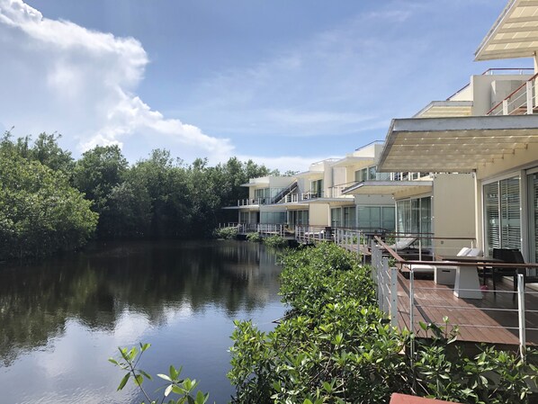 Un hotel moderno con vista al lago, que cuenta con varios balcones y un entorno lacustre tranquilo.