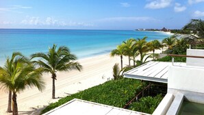 Blick auf einen Strand mit Palmen und blauem Himmel.