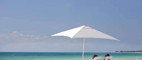 På stranden, vit sandstrand, solstolar och parasoller