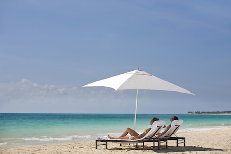 On the beach, white sand, sun loungers, beach umbrellas