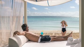 Relax on a sunbed with a refreshing drink, overlooking the ocean.