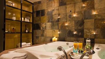 A bathroom with a bathtub, a glass shower enclosure, and a shelf with toiletries.