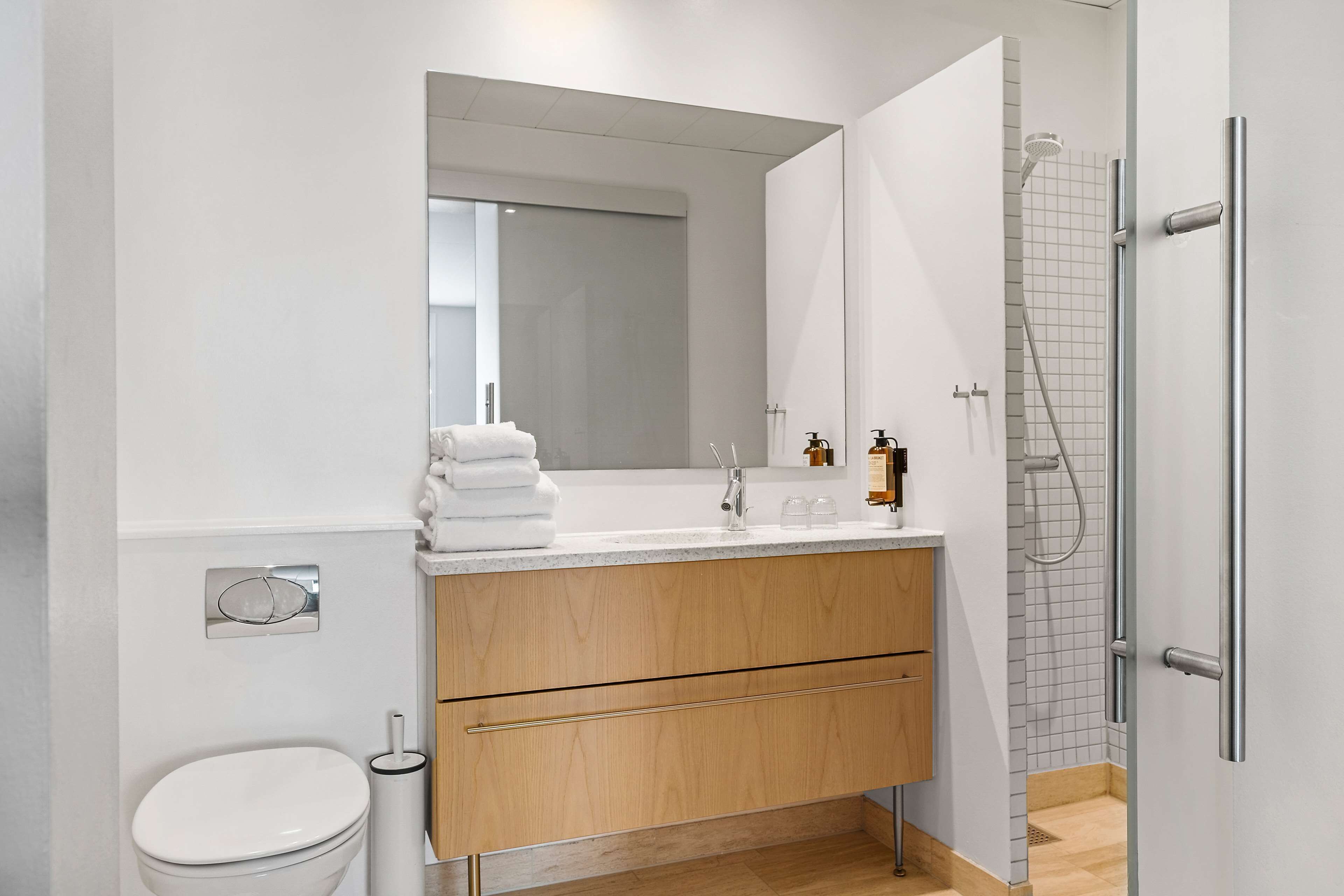 Un baño moderno con inodoro, lavamanos y ducha.