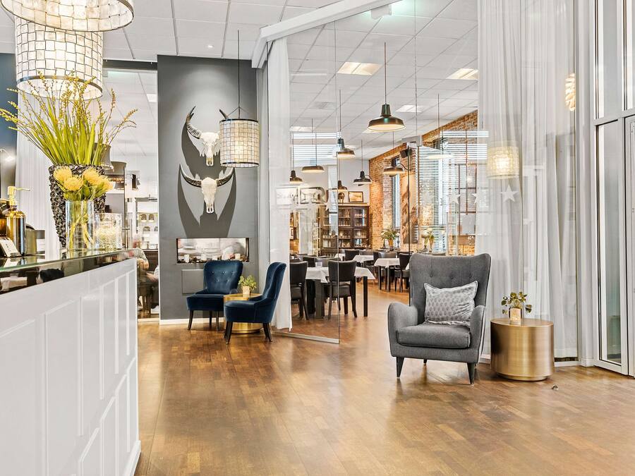 A modern interior with a wooden floor, a bar area, and seating arrangements.