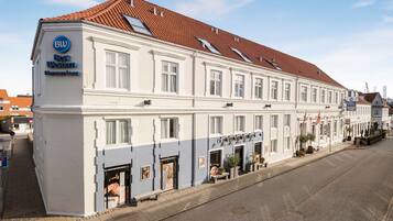 Een wit gebouw met een rode pannendak, aangeduid als "BW Best Western".