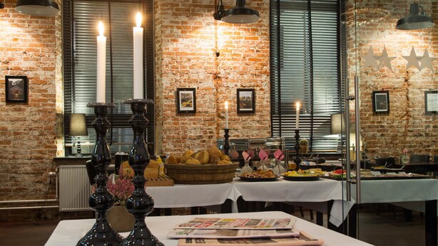Un restaurante con paredes de ladrillo, velas y una variedad de comida exhibida en las mesas.