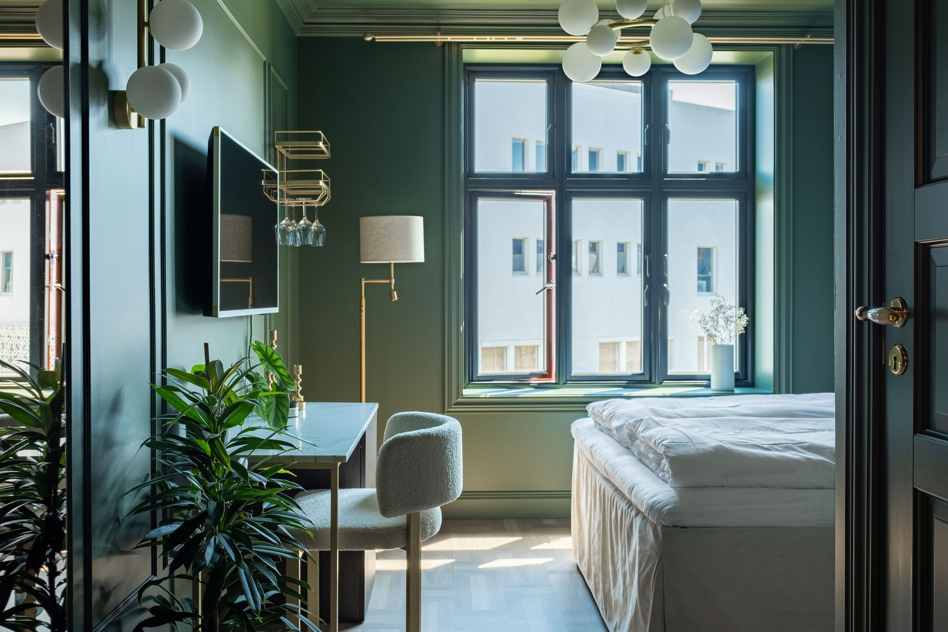 Quarto moderno com uma grande janela, mesa de cabeceira, cadeira e cama.