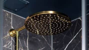 A modern shower with a golden finish and a rain shower head.