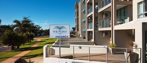 A modern apartment building with a sign indicating a vacancy.