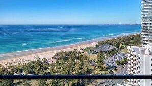 A coastal view from a high-rise building overlooking a beach with a parking area and a few buildings in the foreground. - ULTIQA Beach Haven At Broadbeach (Broadbeach)