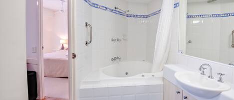 A bathroom with a bathtub, a sink, and a shower.