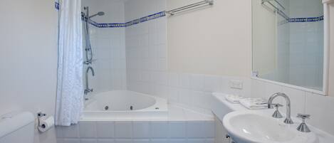 Un baño con bañera, lavamanos e inodoro.