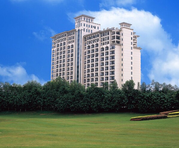 A high-rise building with multiple balconies and a central glass elevator shaft. - The Star River Apartment (Guangzhou)