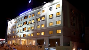A multi-story hotel with illuminated windows and a prominent sign.