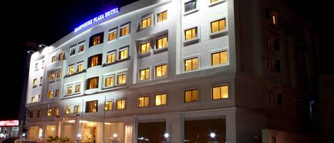 A multi-story hotel with illuminated windows and a prominent sign.