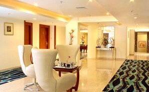 A hotel lobby with a reception desk, seating area with chairs, and a patterned carpet. - Hampshire Plaza Hyderabad (Hyderabad)