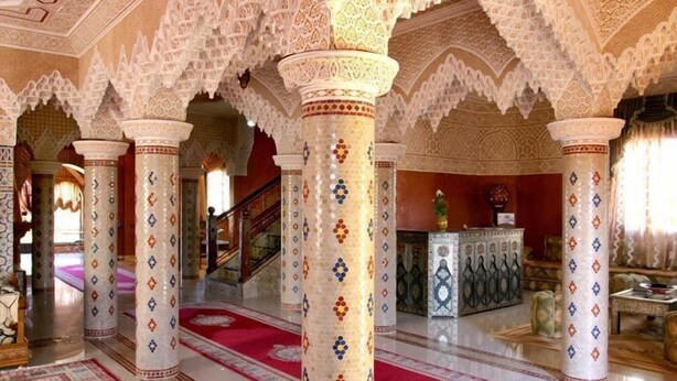 An interior with ornate columns, a red carpet, and a staircase. - Palais Dar Ouladna (Marrakech)