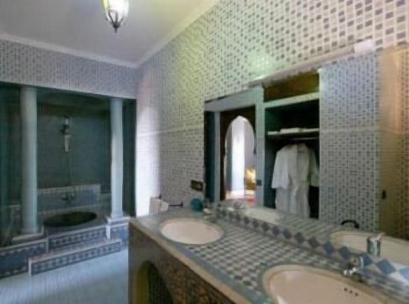 Une salle de bain avec deux lavabos, un miroir et un porte-serviettes.