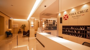 Una zona reception con un bancone, esposizione di scarpe e un cartello per Vera Cruz Porto Hotel Downtown.