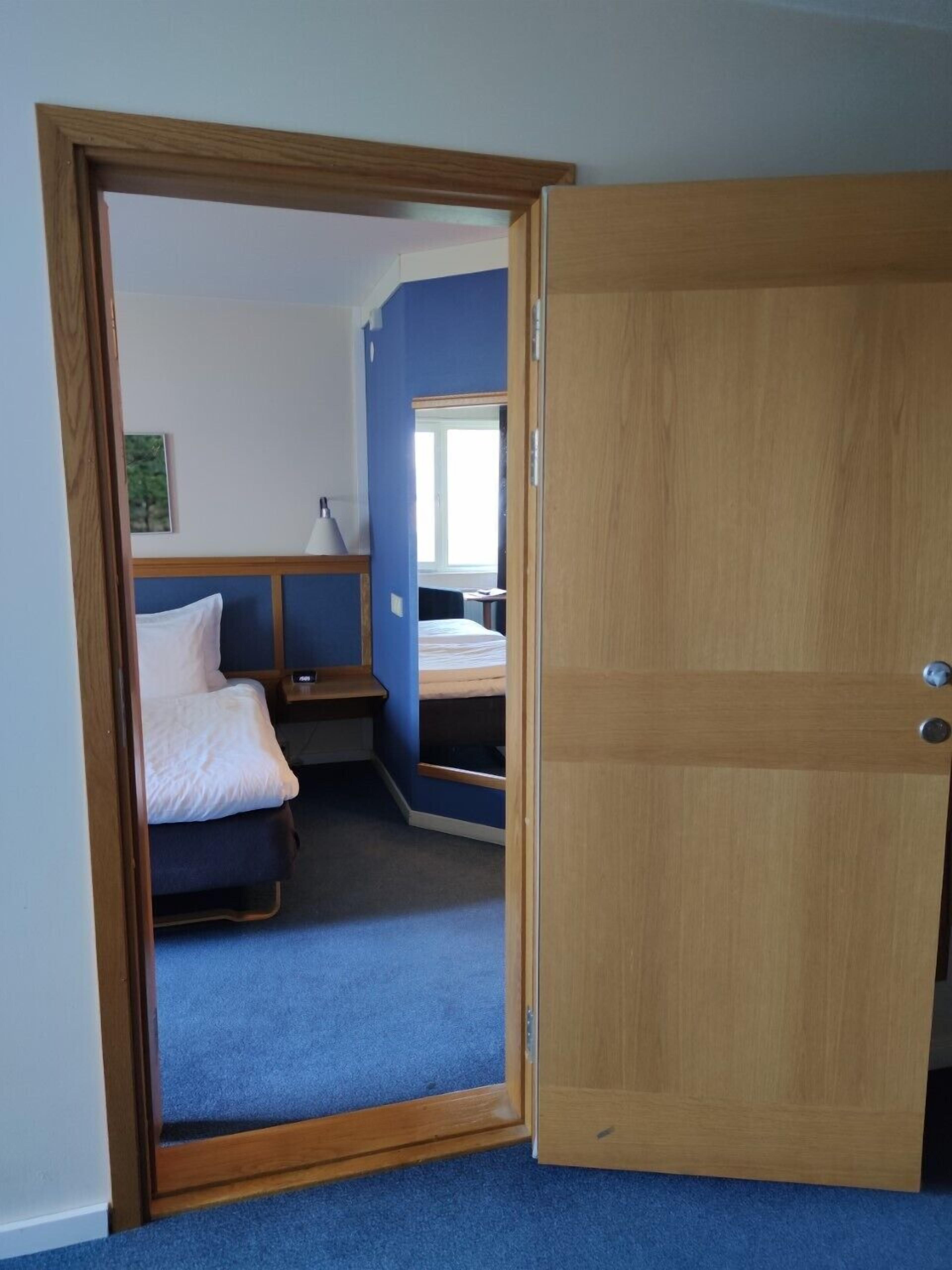 A room with a bed, a desk, and a window.