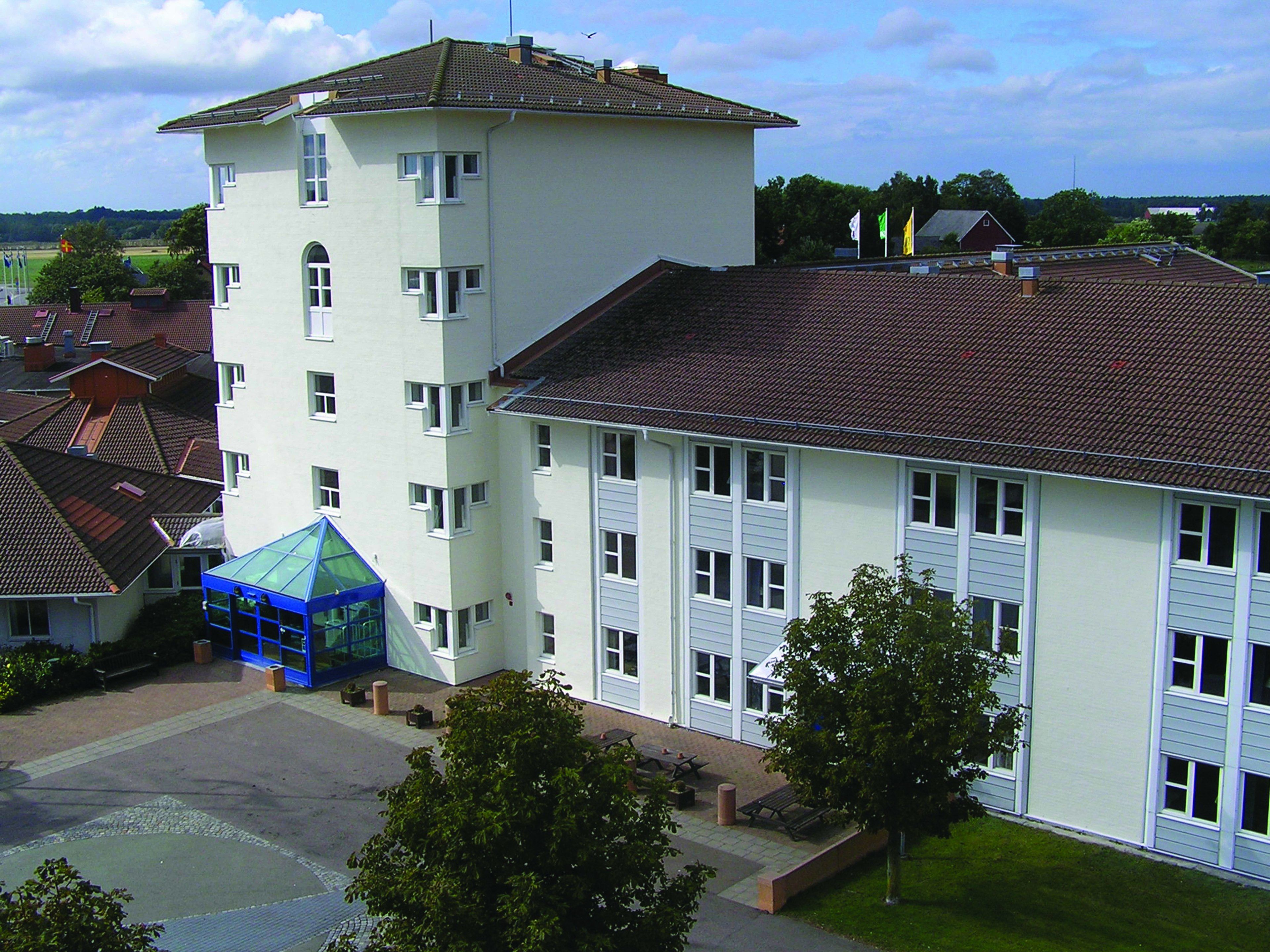 A multi-story building with a flat roof and a blue structure on the ground floor.