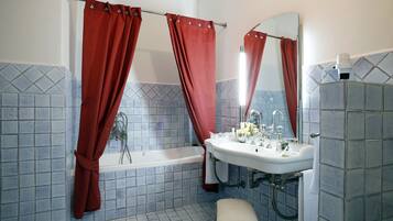 A bathroom with a bathtub, a sink, and a mirror.