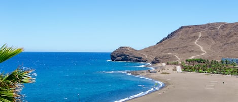 En la playa, playa de arena negra, toallas de playa y buceo 