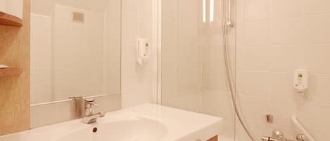 Une salle de bain moderne avec un double vasque, une douche Ă parois de verre et un grand miroir.