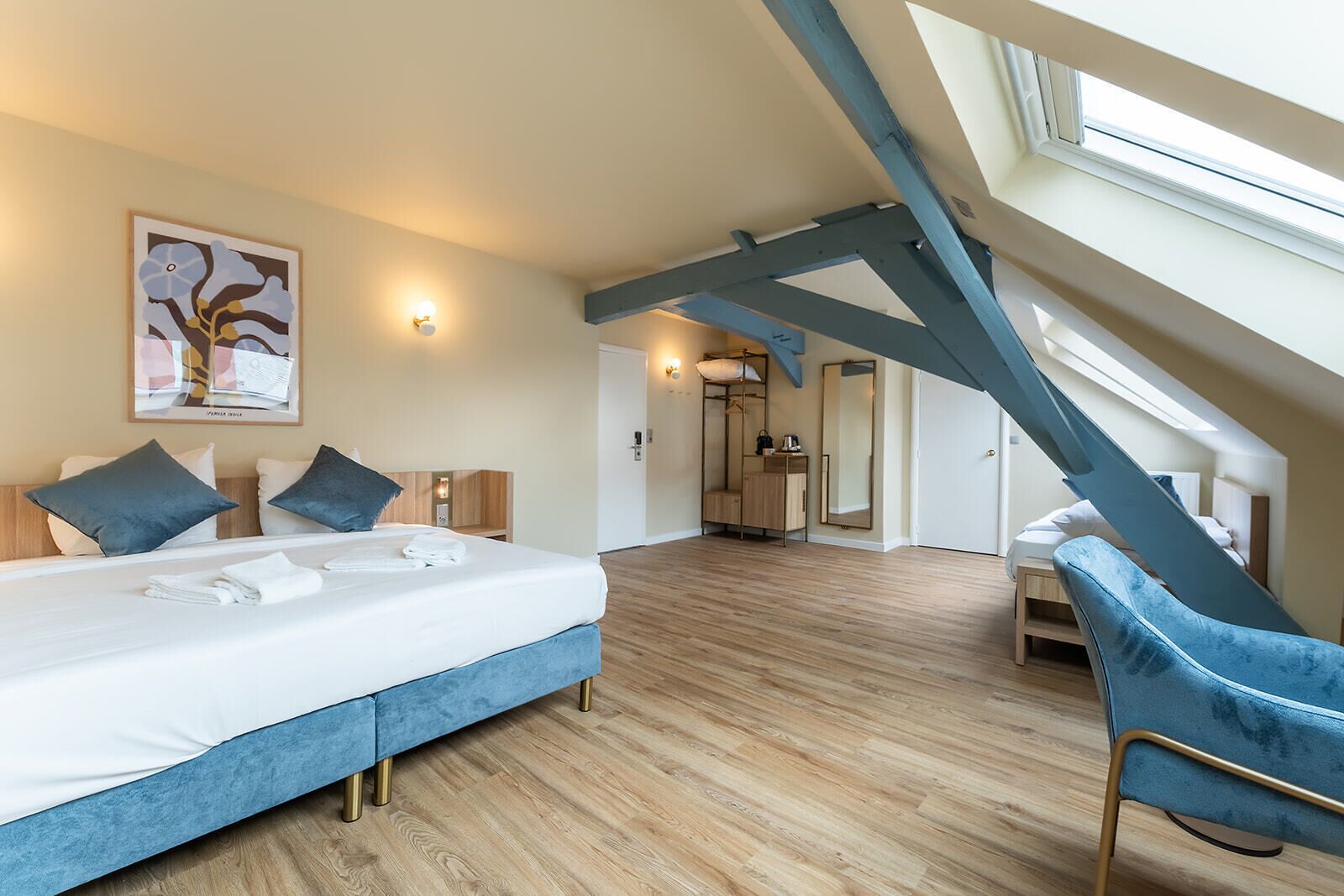 A bedroom with a bed, a chair, a wardrobe, and a skylight.