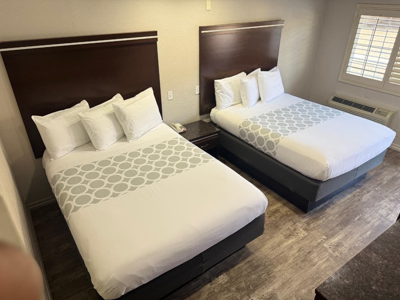 Two adjacent beds with matching headboards and a patterned bedspread.