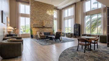 A spacious living area with a stone accent wall, modern furniture, and large windows.