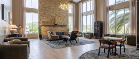 A spacious living area with a stone accent wall, modern furniture, and large windows.