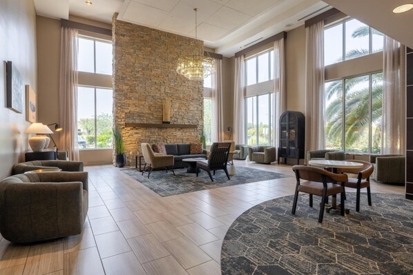 A spacious living area with a stone accent wall, modern furniture, and large windows.