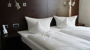 Ein Hotelzimmer mit einem großen Bett, zwei Nachttischen und Wandleuchten.