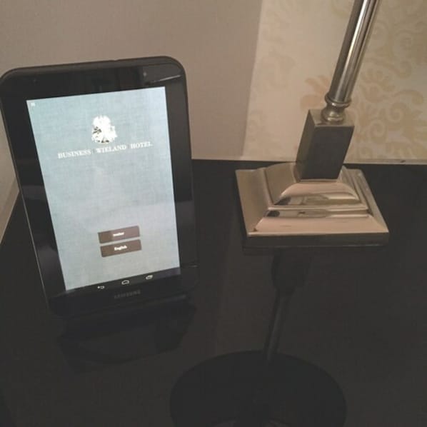 Una tableta Samsung muestra una interfaz de reserva de hotel para Business Wellington Hotel.
