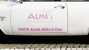 Ein weißes Auto vor einem Gebäude mit der Aufschrift 'Hotel Lasthaus AM Ring'.