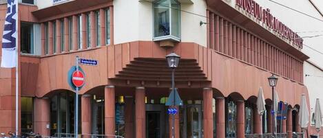 A building with a prominent 'Museum für Moderne Kunst' sign, a no-entry sign, and a row of bicycles parked outside.