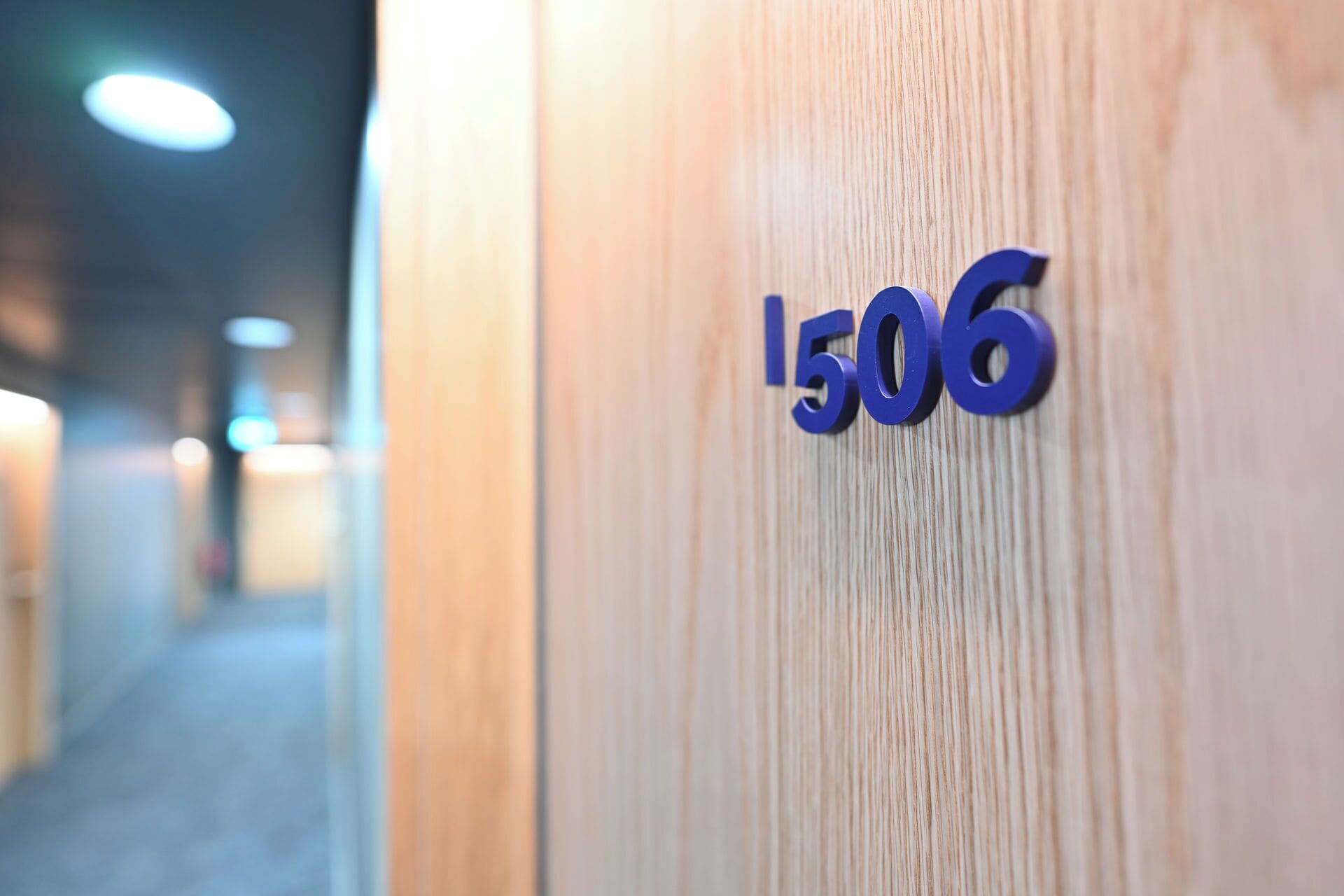 Een close-up van een houten deur met het cijfer '1506' in het blauw.