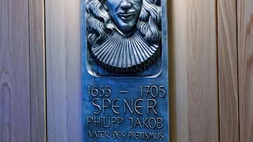 A plaque with a portrait and text on a wooden door.