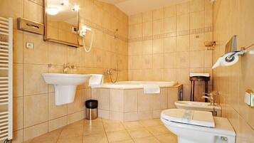 Un baño moderno con lavamanos, bañera, inodoro y ducha.